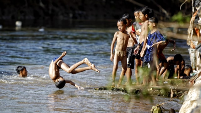 Anak kecil berenang di Sungai Ciliwung (Foto: Aditia Noviansyah/kumparan)