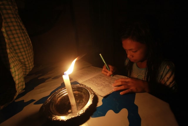 Belajar di tengah cahaya lilin  (Foto: Adiwinata Solihin/Antara)