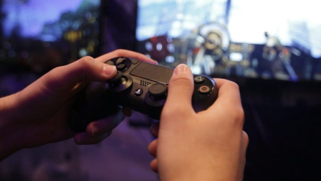 Bermain konsol game Sony PlayStation 4. (Foto: Ina Fassbender/Reuters)