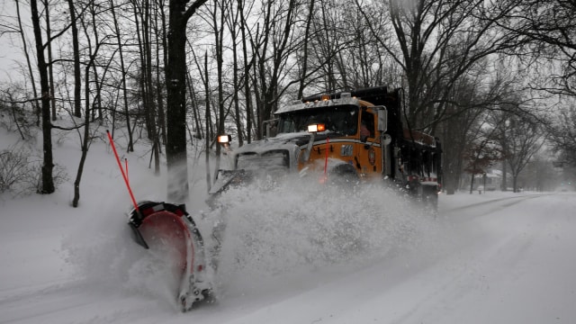 Mobil pengeruk salju bekerja saat badai salju. (Foto: Reuters/Mike Segar)