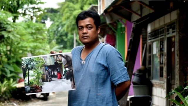 Warga kampung menunjukkan wajah masa lalu kampung. (Foto: Bay Ismoyo/AFP)