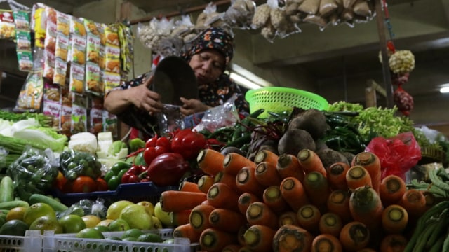 Seorang penjual dan dagangannya di pasar (Foto: Fanny Kusumawardhani/kumparan)