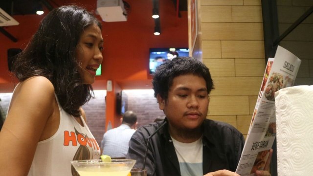 Pelayan sedang menjelaskan hidangan Hooters (Foto: Nikolaus Harbowo/kumparan)