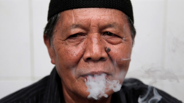 Seorang laki-laki sedang merokok. (Foto: Reuters/Beawiharta)