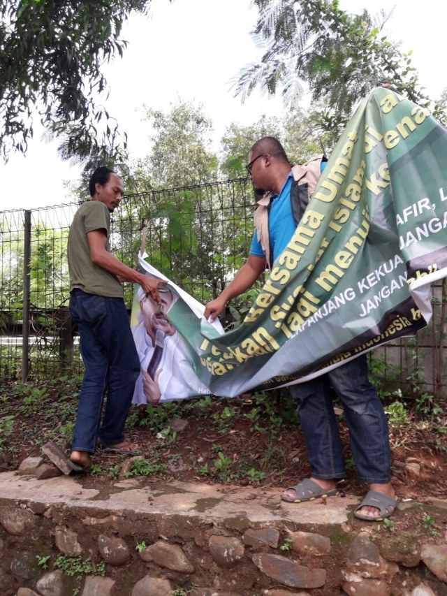 Timses Anies-Sandi menurunkan spanduk. (Foto: Dok. Tim Anies-Sandi)