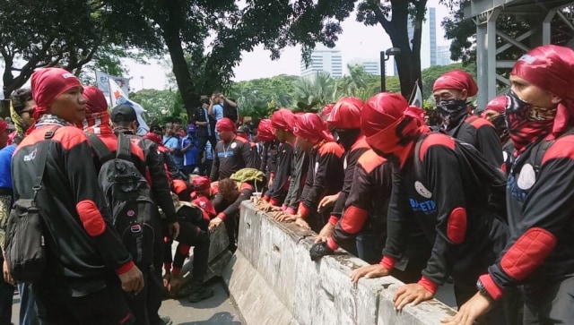 Beton pembatas jalan dibongkar paksa oleh buruh (Foto: Aria Pradana/kumparan)