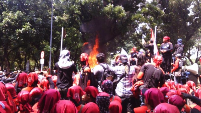 Buruh bakar karangan bunga Ahok. (Foto: Dok. Embed pembaca)