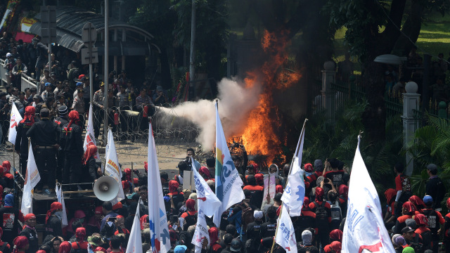 Polisi padamkan karangan bunga Ahok di demo buruh (Foto: Sigid Kurniawan/ANTARA)