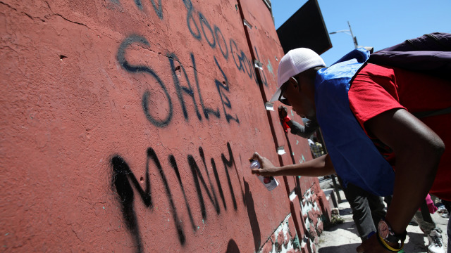 Massa buruh menuliskan aspirasinya di tembok. (Foto: EUTERS/Andres Martinez Casares)