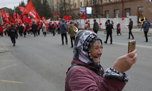 Seorang nenek selfie di tengah aksi buruh. (Foto: REUTERS/Ilya Naymushin)
