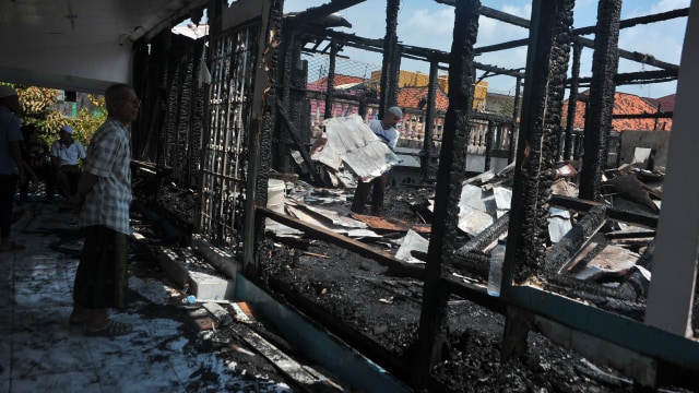 Pemilik memperhatikan rumah yang terbakar (Foto: Feny Selly/ANTARA)