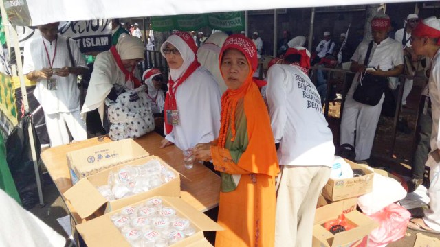 Ibu-ibu membagikan minuman gratis di Istiqlal. (Foto: Johanes Hutabarat/kumparan)