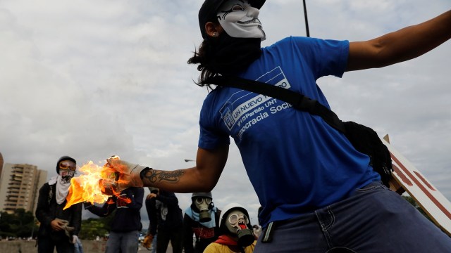 Demonstran melempar bom molotov di Venezuela. (Foto: REUTERS/Christian Veron)