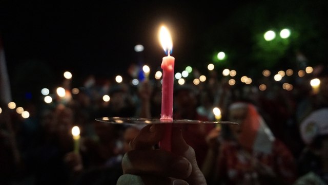 Massa menyalakan lilin di Silang Monas (Foto: Aditia Noviansyah/kumparan)