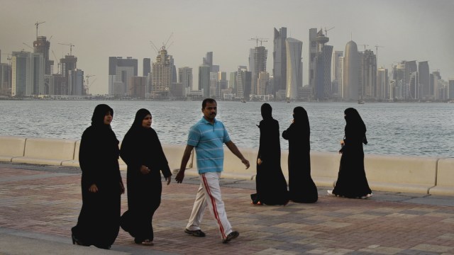 Sejumlah orang berjalan di pinggir kota Doha Qatar (Foto: AP Photo/Kamran Jebreili)