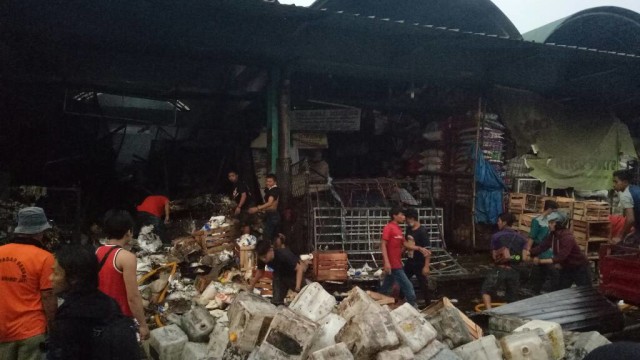 Pekerja pasar mengamankan barang-barang. (Foto: Aria Pradana/kumparan)