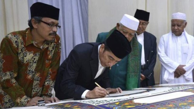 Jokowi menulis di atas Al Quran Akbar  (Foto: Foto: Rusman & Edi - Biro Pers Setpres)