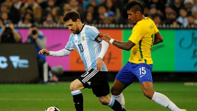 Paulinho (kanan) berebut bola dengan Messi. (Foto: Reuters/Jason Reed)