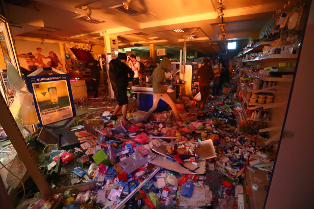 Massa melakukan penjarahan. (Foto: REUTERS/Pawel Kopczynski)