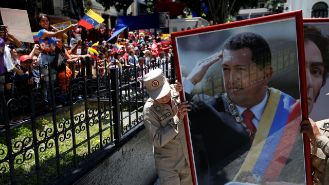 Anggota militer mengangkat foto Hugo Chávez (Foto: REUTERS/Carlos Garcia Rawlins)
