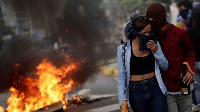 Demonstran dengan latar barikade di Caracas (Foto: REUTERS/Ueslei Marcelino)