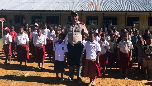 AKBP Juliarman Pasaribu bersama anak SD di Papua (Foto: Polres Pegunungan Bintang)