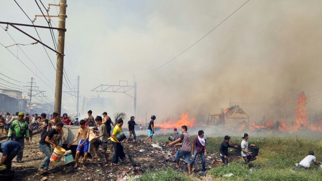 Warga bergotong royong memadamkan api. (Foto: Adim Piero/kumparan)