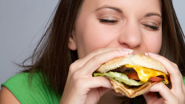 Ilustrasi wanita konsumsi hamburger (Foto: Thinkstock)