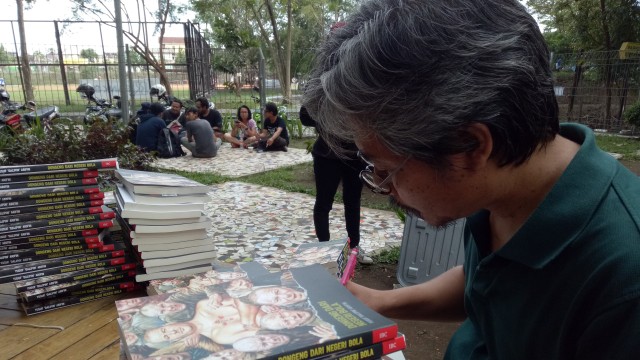 Yusuf Arifin dan buku "Dongeng dari Negeri Bola". (Foto: Yoga Cholandha/kumparan)
