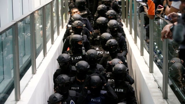 Polisi mengawal Siti Aisyah menuju Bandara KL (Foto: REUTERS/Lai Seng Sin)