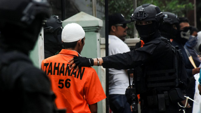 Densus 88 mengawal dugaan tersangka teror (Foto: Timur Matahari / AFP)