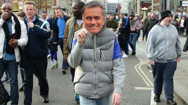 Seorang suporter dengan topeng Mourinho. (Foto: LEON NEAL / AFP)