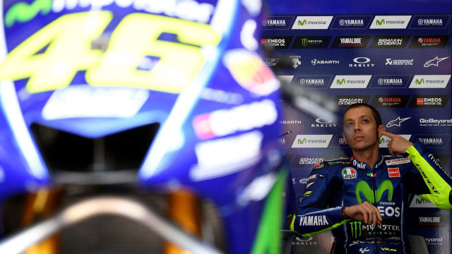 Rossi bersama motornya di paddock. (Foto: Manan VATSYAYANA / AFP)