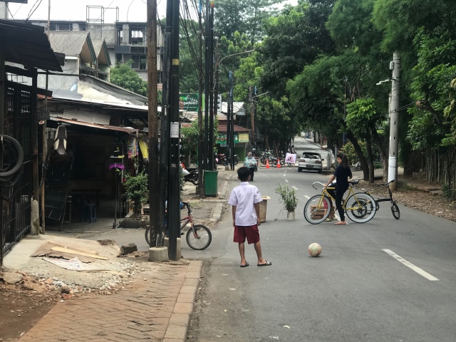 Seorang bocah bermain bola di jalan raya. (Foto: Adhie Ichsan)