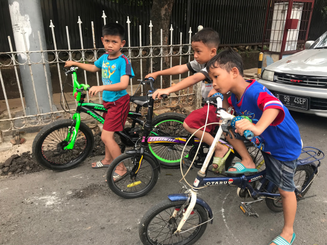 Anak-anak bermain sepeda di jalan raya (Foto: Adhie Ichsan)