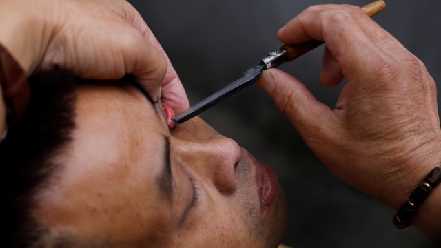 Mencukur dan membersihkan mata di China (Foto: Reuters/Tyrone Siu)