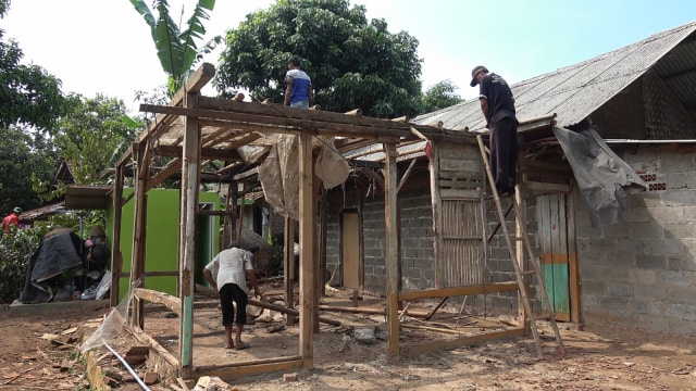 Bripka Prima membantu benahi Rumah Ibu Sawani. (Foto: Fadjar Hadi/kumparan)