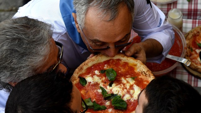 Memakan pizza (Foto: AFP/Tiziana Fabi)
