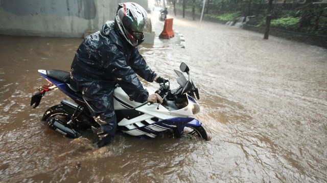 Motor melintasi banjir di Semanggi, Jakarta (Foto: ANTARA/Muhammad Adimaja)