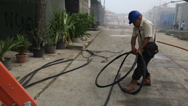 Petugas merapihkan kabel listrik yang terbakar.  (Foto: fachtur Irwinsyah/kumparan)