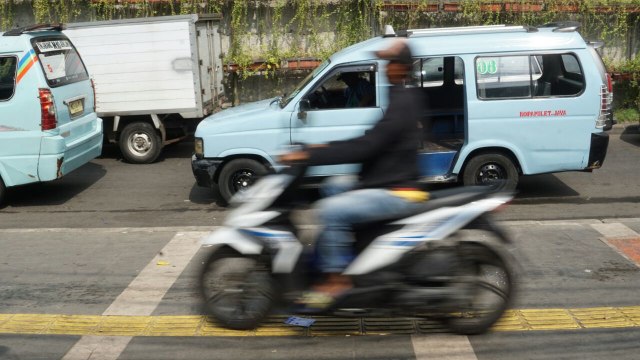 Pengguna sepeda motor melintasi trotoar  (Foto: Jamal Ramadhan/kumparan)