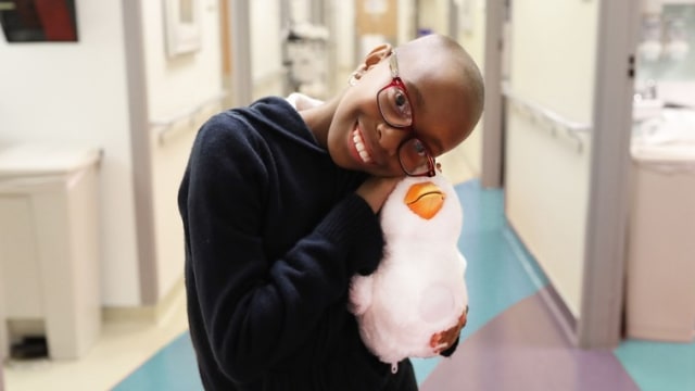 Anak pengidap kanker memeluk robot bebek Aflack. (Foto: Aflack)