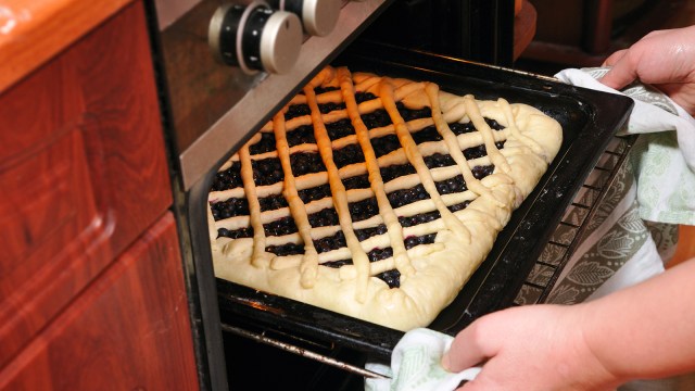 Membuka pintu oven saat memanggang kue (Foto: Thinkstock)