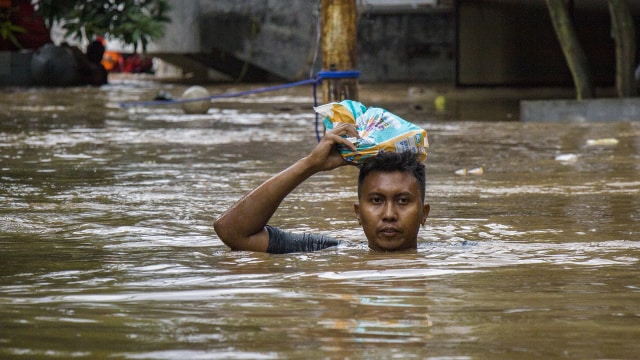 Warga menerobos banjir di Pejaten Timur (Foto: ANTARA FOTO/Galih Pradipta)