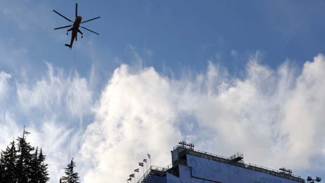 Helikopter mondar-mandir di Cypress angkut salju (Foto: Adrian Dennis/AFP)