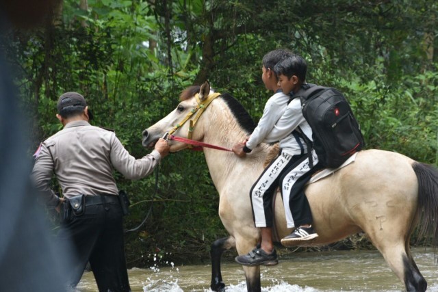 Polisi Ini Gunakan Kuda untuk Sebrangkan Siswa di Sungai Rondoningo