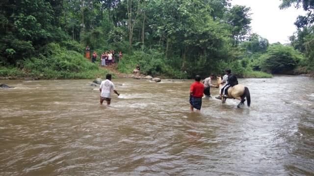 Polisi Ini Gunakan Kuda untuk Sebrangkan Siswa di Sungai Rondoningo (1)