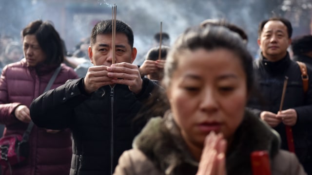 Masyarakat China berdoa saat Tahun Baru Imlek (Foto: GREG BAKER / AFP)
