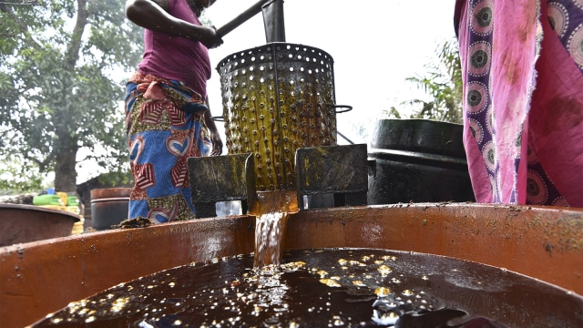 Warga memeras minyak dari kelapa sawit (Foto: AFP PHOTO / Sia KAMBOU)