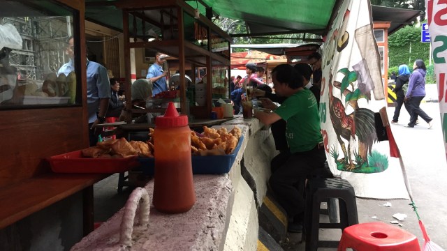 Pembatas jalan jadi meja makan di Jalan Sudirman. (Foto: Soejono Eben Ezer Saragih/kumparan)